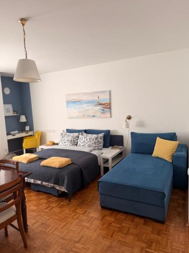 Savremeno uređen enterijer dnevnog boravka Apartment Svetionik sa sivim kaučem, modernim detaljima i drvenim podom.
