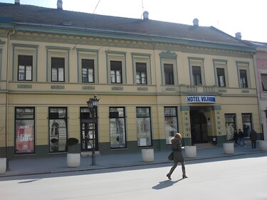 Tradicionalna, dugačka bledožuta fasada istorijskog hotela Vojvodina na Trgu slobode u Novom Sadu.