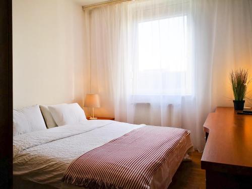 Moderan enterijer dnevnog boravka Central Suite La Gala sa sivim kaučem, svetlim zidovima i izlazom na balkon.